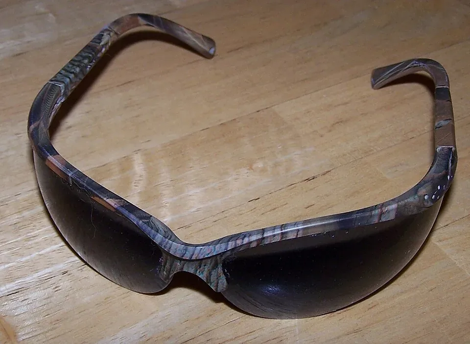 Lunettes de sécurité à branches posées sur une table en bois