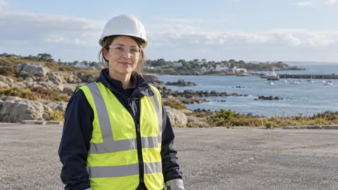 Personne fictive équipée devant une côte de granit et un petit port, dans un cadre inspiré de la région Bretagne